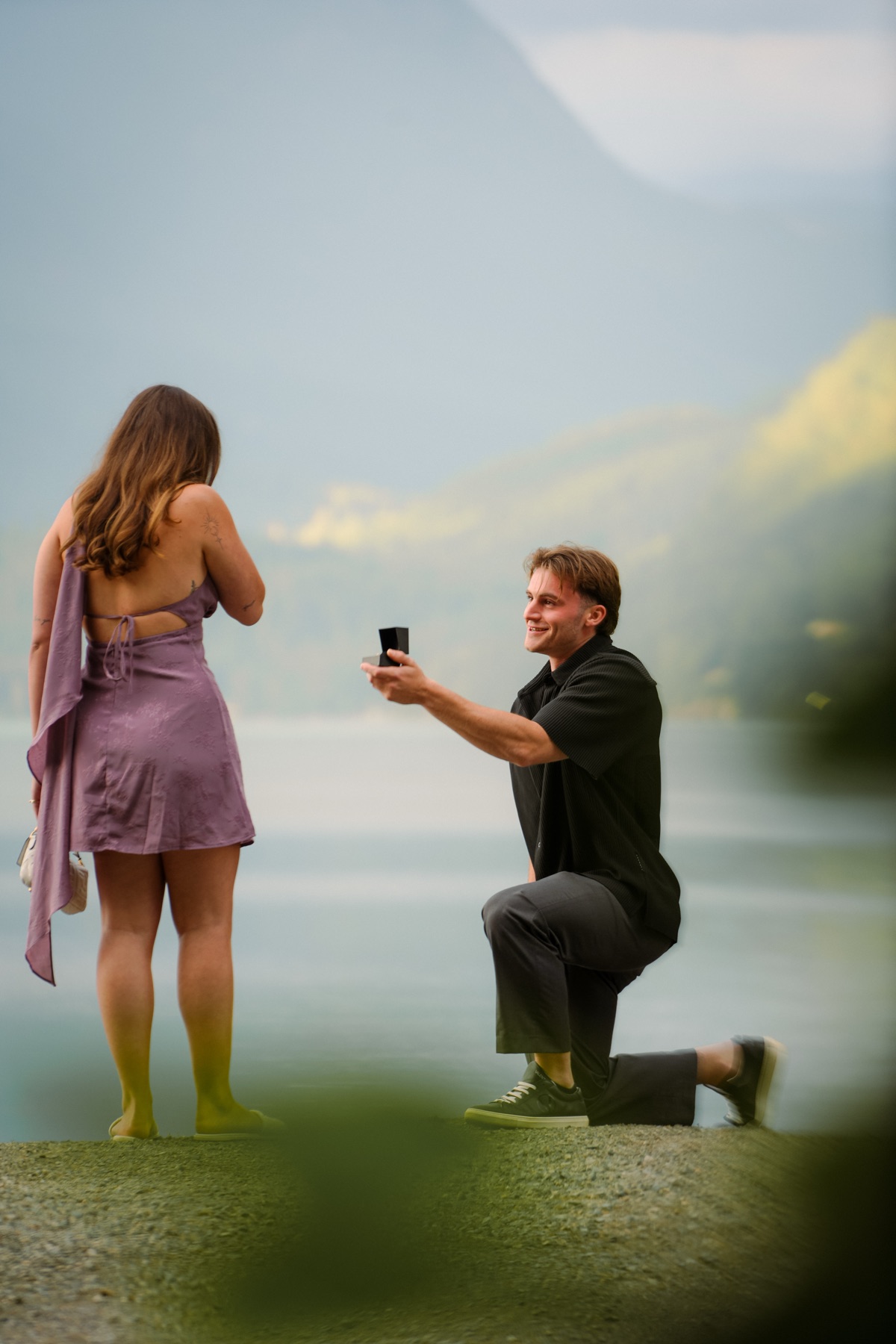 A proposal at the lakeshore, mountains behind