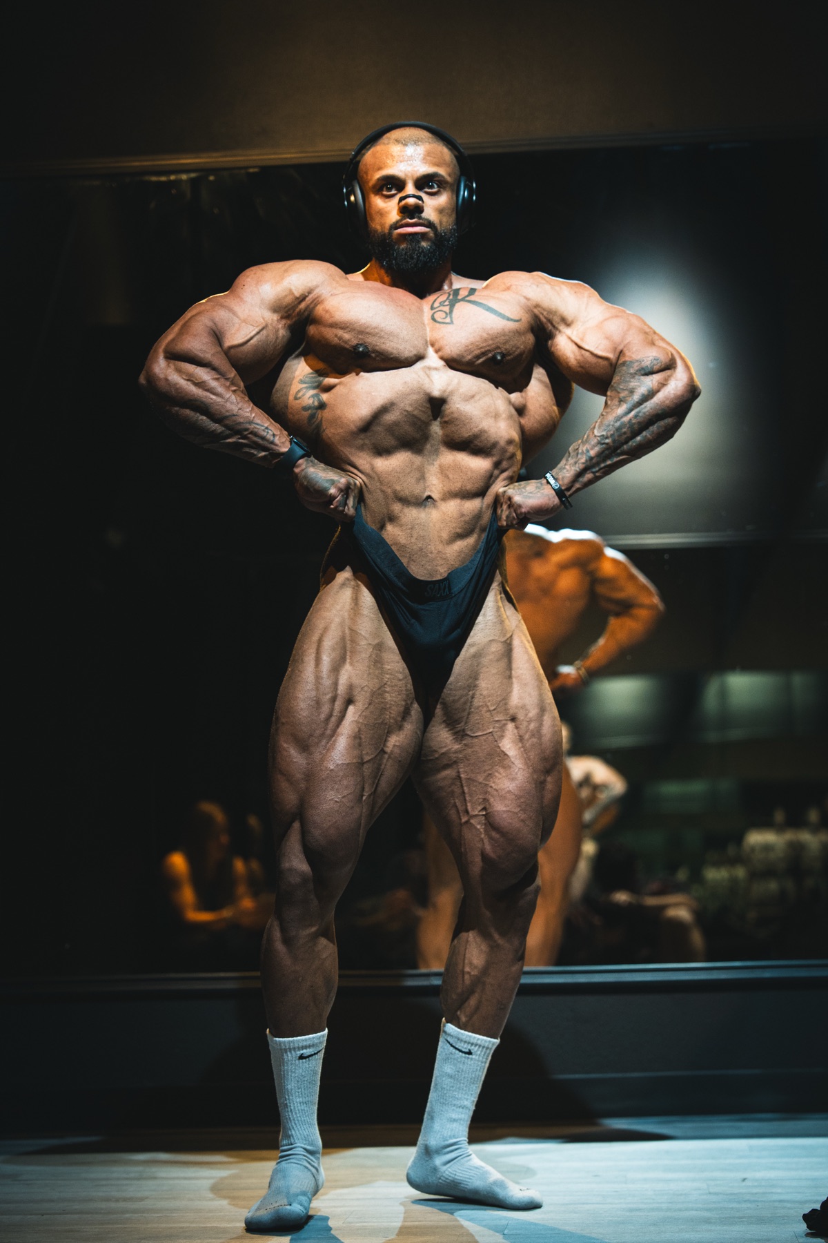 Kellen Wilson holding a front lat spread backstage
